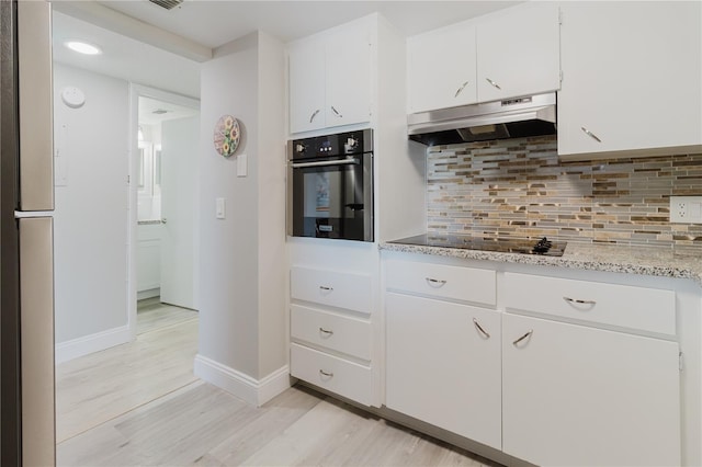 2457 Ecuadorian Way Unit 63, Clearwater, FL 33763 - kitchen with oven, light wood-type flooring, white cabinetry, under cabinet range hood, and backsplash