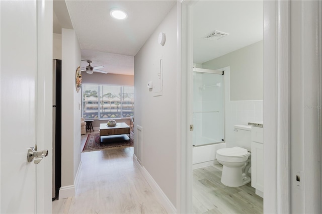 2457 Ecuadorian Way Unit 63, Clearwater, FL 33763 - bathroom with ceiling fan, toilet, wood finished floors, visible vents, and bath / shower combo with glass door
