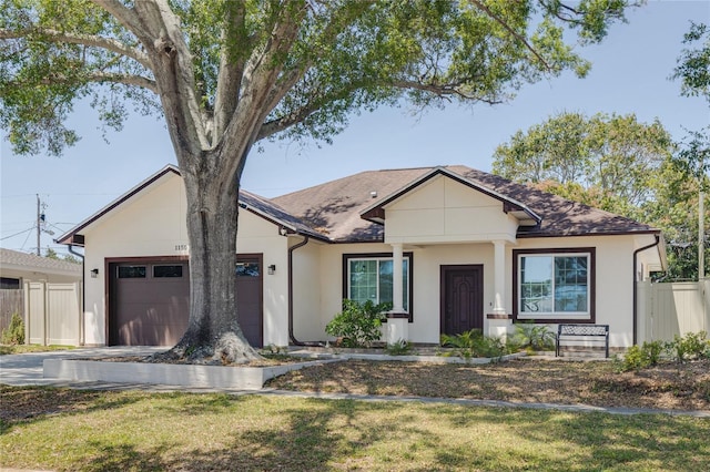 single story home featuring a front lawn, a garage, driveway, stucco siding, and fence