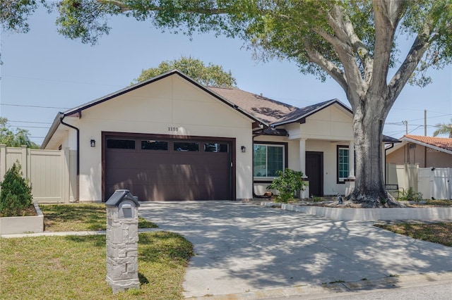 ranch-style home with a garage, fence, stucco siding, and concrete driveway