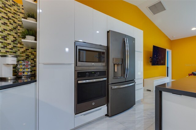 kitchen featuring marble finish floor, visible vents, vaulted ceiling, white cabinets, and appliances with stainless steel finishes