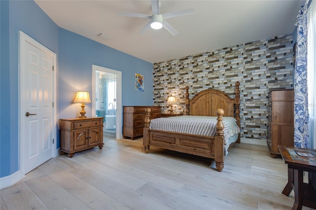 bedroom with visible vents, ceiling fan, connected bathroom, and light wood finished floors