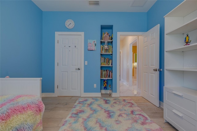 bedroom with baseboards, visible vents, and light wood-style floors