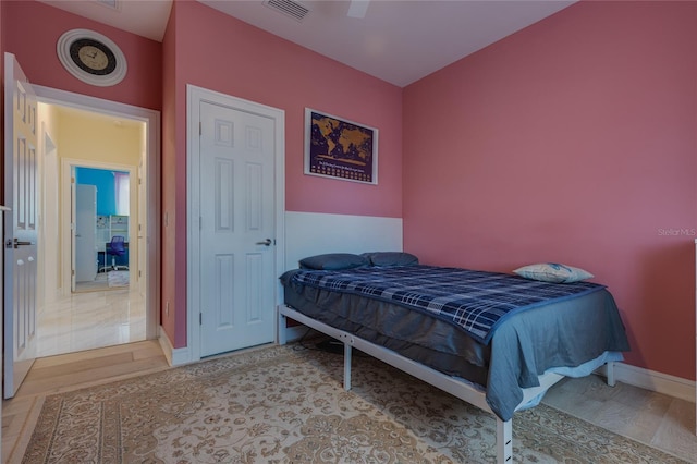 bedroom with wood finished floors, visible vents, ceiling fan, and baseboards