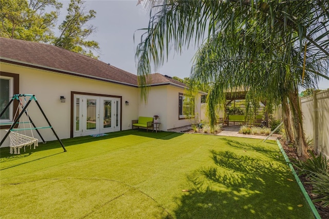 back of house with fence, french doors, stucco siding, and a yard