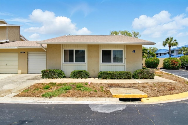 1671 Cape Ann Ave NE Unit 4, Saint Petersburg, FL 33702 - view of front facade featuring stucco siding, driveway, and an attached garage