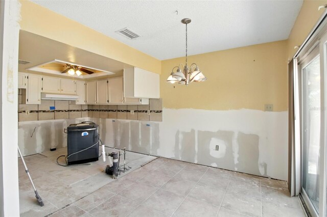 1671 Cape Ann Ave NE Unit 4, Saint Petersburg, FL 33702 - kitchen featuring pendant lighting, visible vents, a tray ceiling, under cabinet range hood, and ceiling fan with notable chandelier