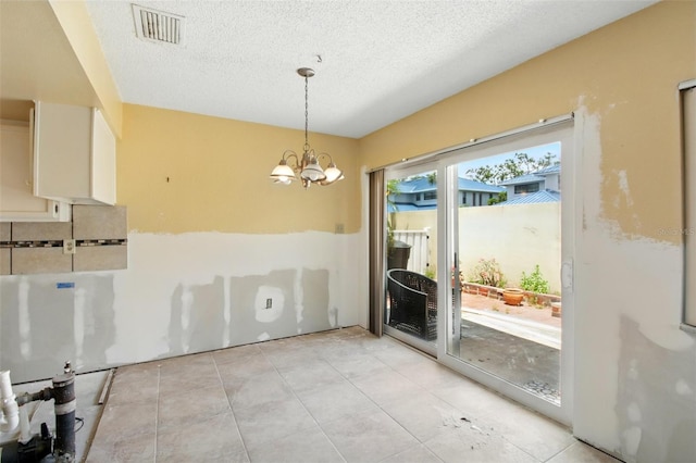 1671 Cape Ann Ave NE Unit 4, Saint Petersburg, FL 33702 - unfurnished dining area featuring light tile patterned floors, a notable chandelier, a textured ceiling, and visible vents