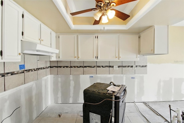 1671 Cape Ann Ave NE Unit 4, Saint Petersburg, FL 33702 - kitchen with decorative backsplash, white cabinets, a raised ceiling, under cabinet range hood, and a ceiling fan