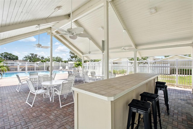 1671 Cape Ann Ave NE Unit 4, Saint Petersburg, FL 33702 - view of patio with outdoor dry bar, a ceiling fan, a fenced in pool, and a fenced backyard