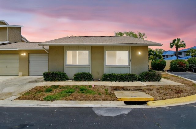 1671 Cape Ann Ave NE Unit 4, Saint Petersburg, FL 33702 - view of front of home with stucco siding, roof with shingles, concrete driveway, and a garage