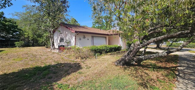 8623 Stonehedge Way, Hudson, FL 34667 - view of side of property with stucco siding and a yard