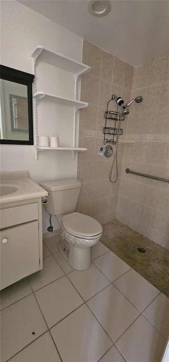 8623 Stonehedge Way, Hudson, FL 34667 - full bathroom with toilet, tiled shower, tile patterned flooring, and vanity