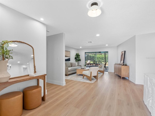 living area with light wood-style floors, baseboards, and recessed lighting