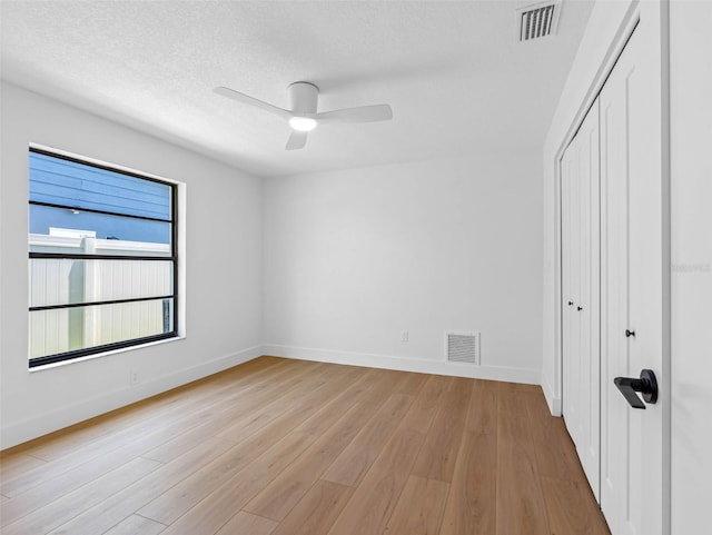 unfurnished bedroom with baseboards, visible vents, light wood-style flooring, and a closet