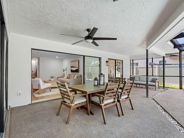 dining room with carpet floors, a textured ceiling, and ceiling fan
