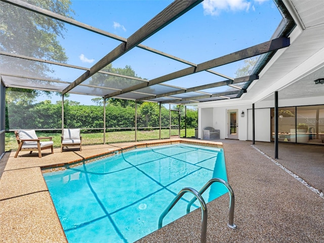 outdoor pool with glass enclosure and a patio area
