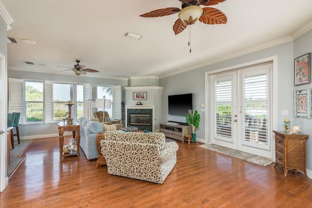 living area with visible vents, a ceiling fan, crown molding, and baseboards