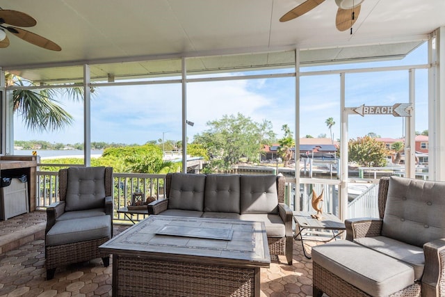 sunroom with ceiling fan, a water view, and outdoor lounge area