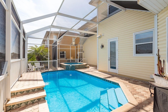 view of pool with a lanai, a patio area, and a pool with connected hot tub