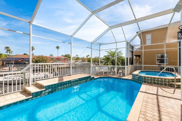 view of swimming pool featuring a lanai, a patio area, and a pool with connected hot tub