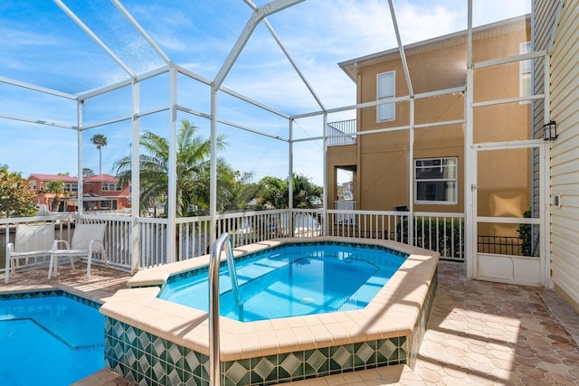 view of swimming pool featuring an in ground hot tub, a fenced in pool, glass enclosure, and a patio area
