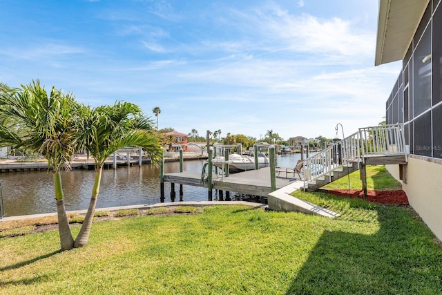 dock area with a lanai, a water view, and a lawn