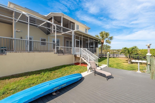 back of house with fence, a deck, a yard, and a sunroom