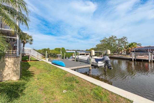 dock area featuring a yard, boat lift, and a water view