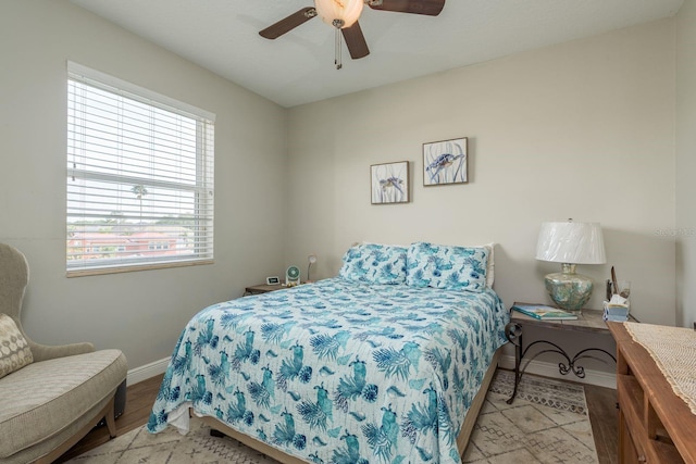 bedroom with baseboards, wood finished floors, and ceiling fan
