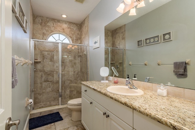 bathroom with tile patterned flooring, toilet, vanity, visible vents, and a stall shower