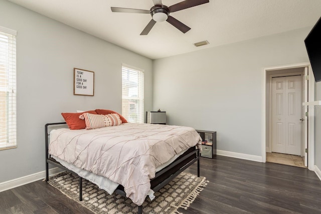 bedroom with baseboards, visible vents, ceiling fan, and dark wood-style flooring