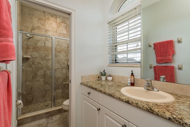 bathroom featuring a stall shower, toilet, and vanity