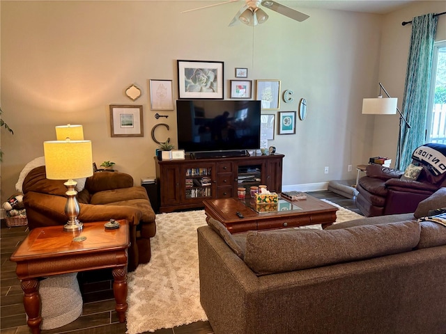 living area with baseboards, a ceiling fan, and wood finished floors