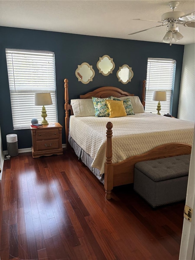 bedroom featuring baseboards, dark wood finished floors, ceiling fan, and multiple windows