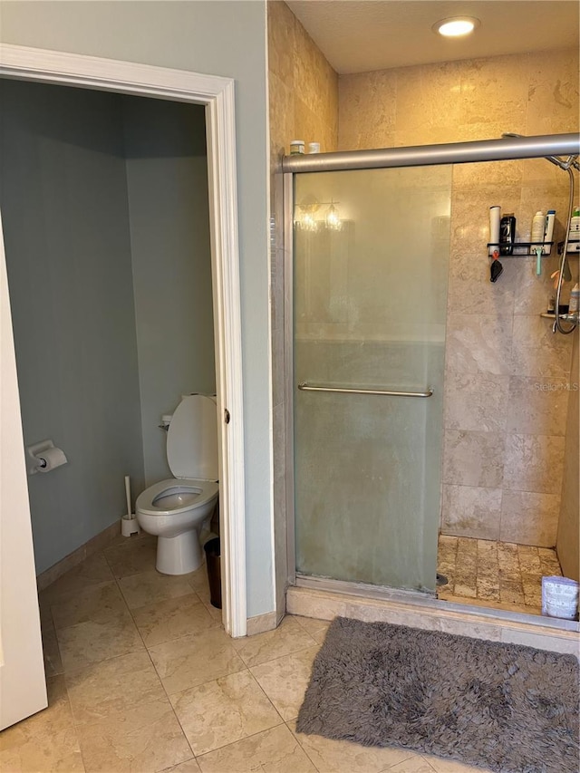 bathroom with a stall shower and toilet