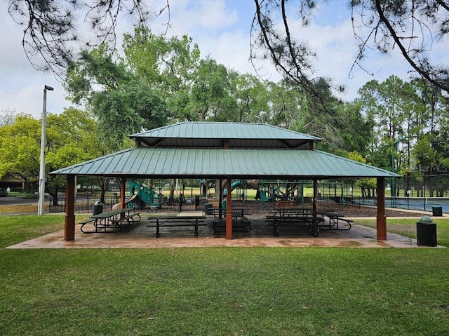 view of community with a yard, a gazebo, fence, and playground community