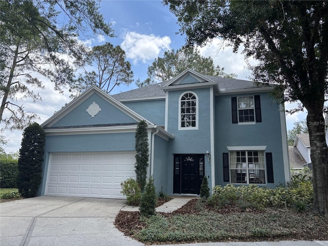 view of front facade featuring a garage, stucco siding, and driveway
