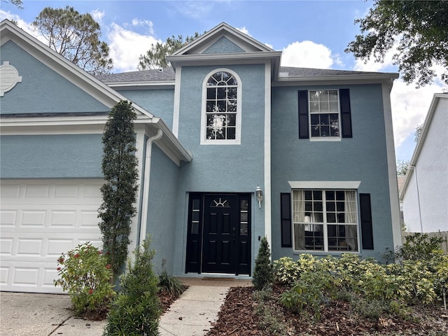 view of front facade with a garage and stucco siding