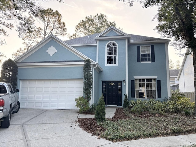 view of front of house with a garage, stucco siding, and concrete driveway