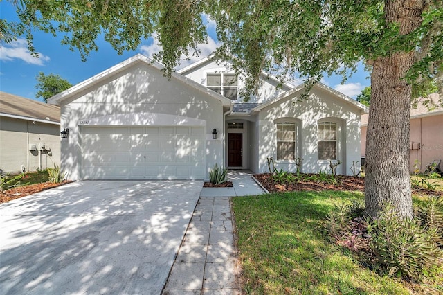 view of front facade featuring concrete driveway, an attached garage, and stucco siding