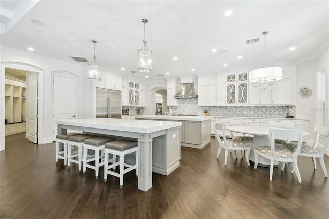 2604 S Bryant Cir, Tampa, FL 33629 - kitchen featuring stainless steel built in fridge, wall chimney exhaust hood, a large island, ornamental molding, and decorative backsplash