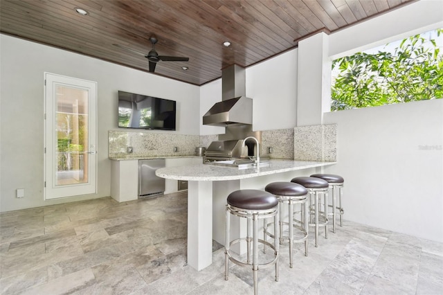 2604 S Bryant Cir, Tampa, FL 33629 - kitchen featuring wood ceiling, refrigerator, tasteful backsplash, a kitchen breakfast bar, and light stone counters