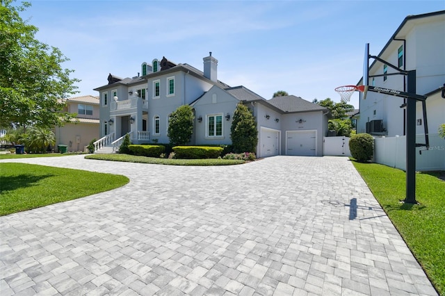 2604 S Bryant Cir, Tampa, FL 33629 - view of front facade with decorative driveway, a garage, stucco siding, a balcony, and a chimney