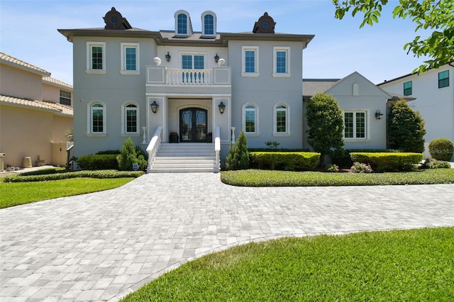 2604 S Bryant Cir, Tampa, FL 33629 - view of front of house featuring french doors, a balcony, stucco siding, and a front lawn