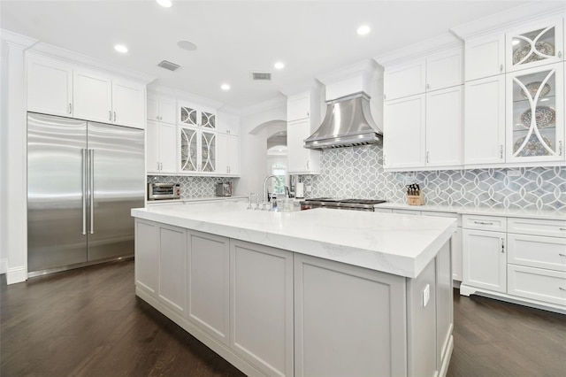 2604 S Bryant Cir, Tampa, FL 33629 - kitchen featuring stainless steel built in refrigerator, premium range hood, arched walkways, white cabinetry, and recessed lighting