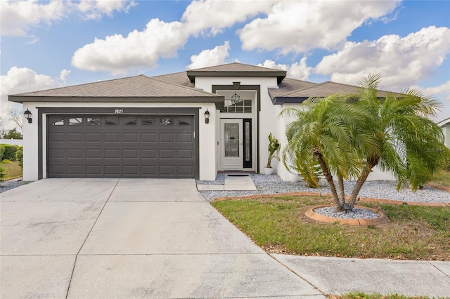 prairie-style home with stucco siding, concrete driveway, and an attached garage