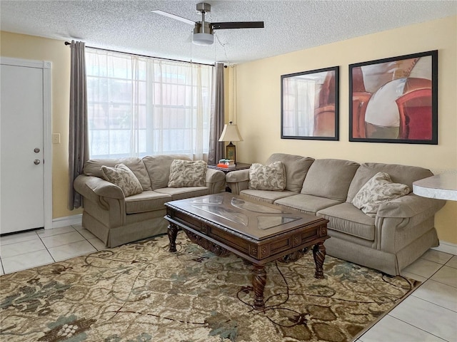 living room featuring light tile patterned floors, a ceiling fan, and a textured ceiling
