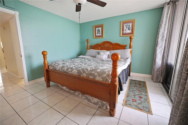 bedroom with a textured ceiling, a ceiling fan, baseboards, and light tile patterned floors