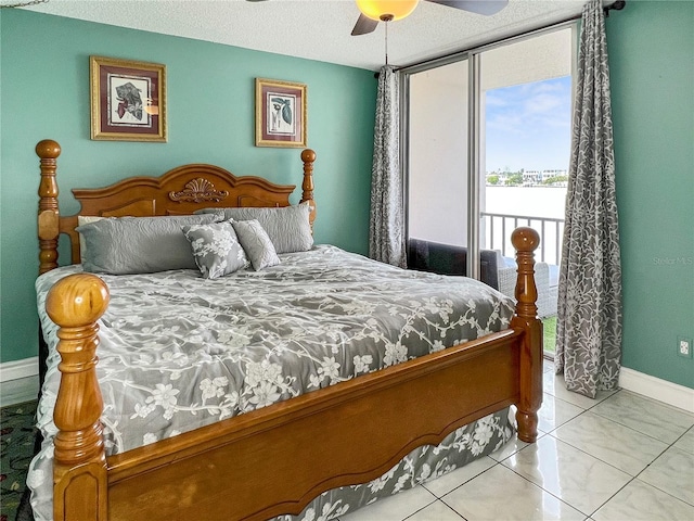 tiled bedroom featuring baseboards, access to exterior, a ceiling fan, and multiple windows